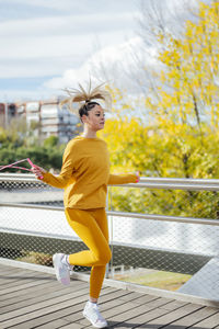 Young athlete skipping rope on bridge