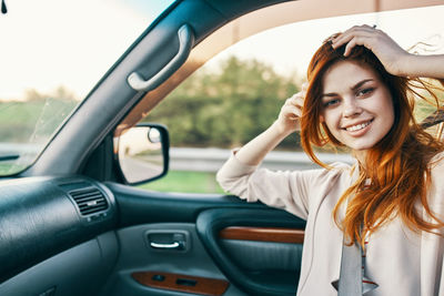 Portrait of smiling young woman in car