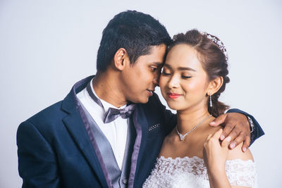 Young couple kissing against white background