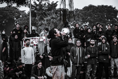 People standing on street against trees