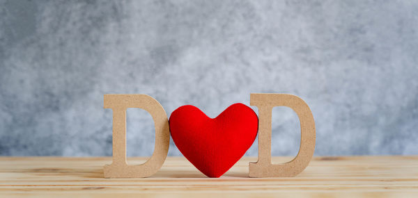 Close-up of heart shape on table against wall