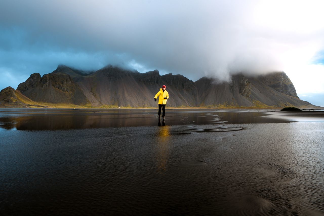 one person, sky, mountain, water, cloud - sky, full length, real people, beauty in nature, lifestyles, scenics - nature, standing, nature, rear view, non-urban scene, men, leisure activity, day, mountain range, outdoors