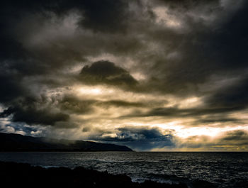 Scenic view of sea against storm clouds