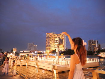 Side view of woman looking at sea against sky