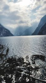 Scenic view of lake by snowcapped mountains against sky