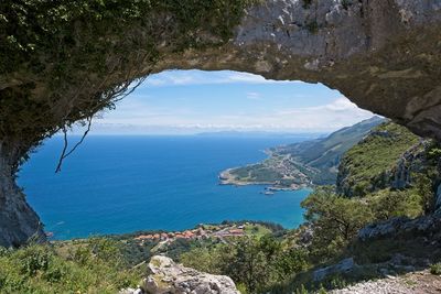 Scenic view of sea and mountains against sky