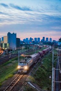 High angle view of railroad tracks amidst buildings in city against sky