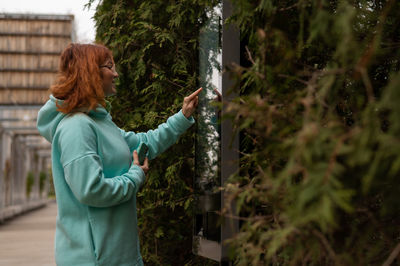 Rear view of woman standing amidst plants