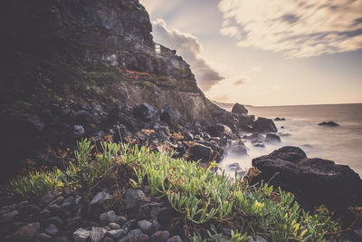 Scenic view of sea and mountains against sky