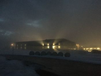Illuminated city against sky at night