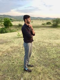 Full length of young man standing on field