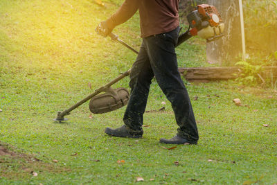 Low section of worker mowing lawn