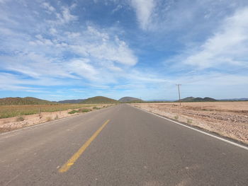 Empty road along countryside landscape