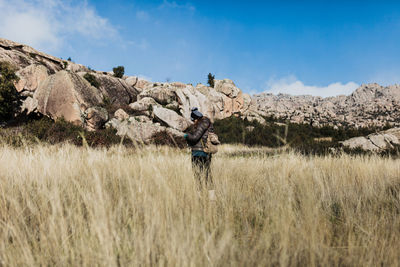 Woman standing on farm against sky
