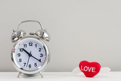 Close-up of heart shape clock on table