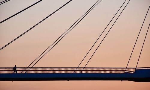 Low angle view of suspension bridge against sky