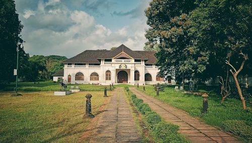 Footpath leading towards building against sky