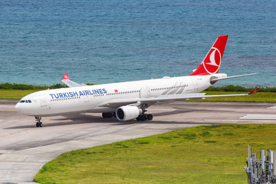 Airplane on airport runway against sky