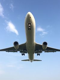 Low angle view of airplane flying against sky