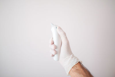 Close-up of hand holding hands over white background