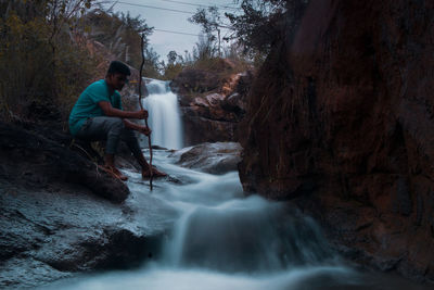 Panoramic shot of man waterfall in forest