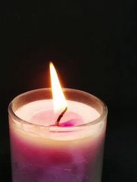 Close-up of burning candle in darkroom