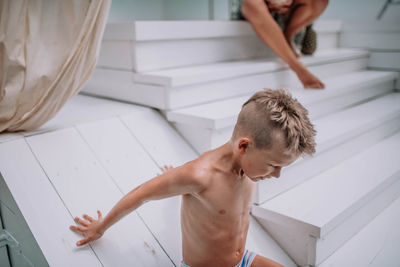 High angle view of shirtless boy in bathroom