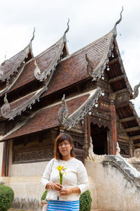 Portrait of smiling woman standing against temple