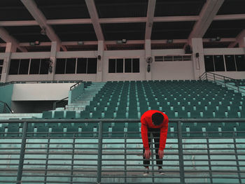 A red sweater man hanging on fence