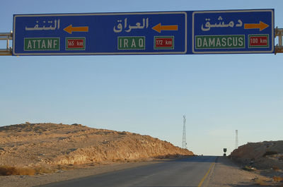 Road sign against sky