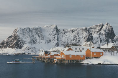 Houses on snowcapped mountain against sky