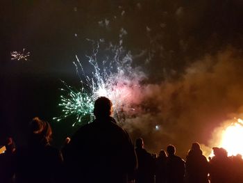 Rear view of silhouette people watching firework display