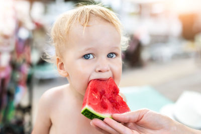Close-up portrait of boy eating fruit