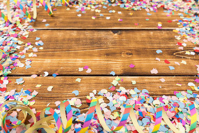 High angle view of colorful confetti on wooden table