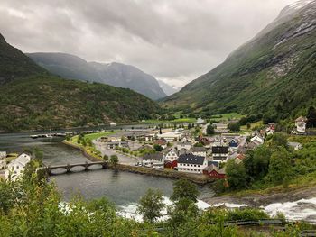 River amidst buildings and mountains against sky