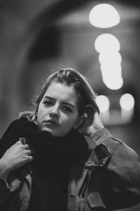 Portrait of young woman holding illuminated lighting equipment