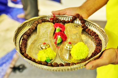 Cropped hand holding paduka in temple