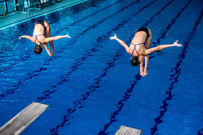 Female athletes jumping in swimming pool