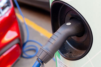 A cable is recharging an electric car at the charging station