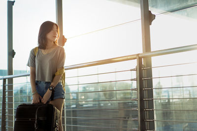 Young woman looking through window