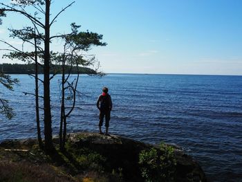 Rear view of man looking at sea against sky