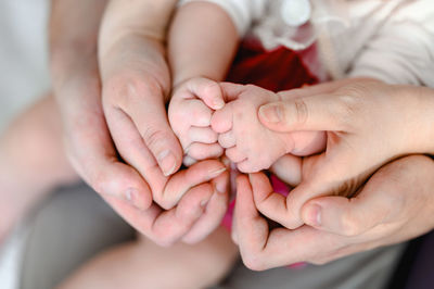 Hands of mom and dad are holding the hands of a little baby. newbon concept