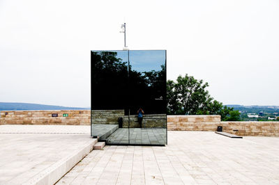 Rear view of man against wall against clear sky