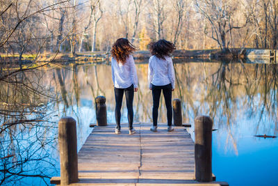 Rear view of women standing by lake