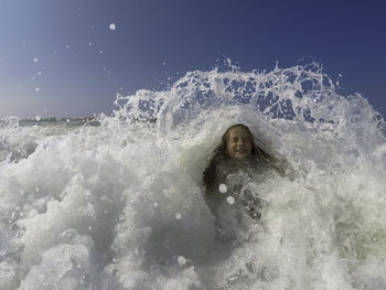 Young woman enjoying wave in sea