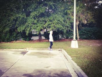 Side view of boy walking on tree