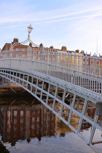 Bridge over river against buildings in city