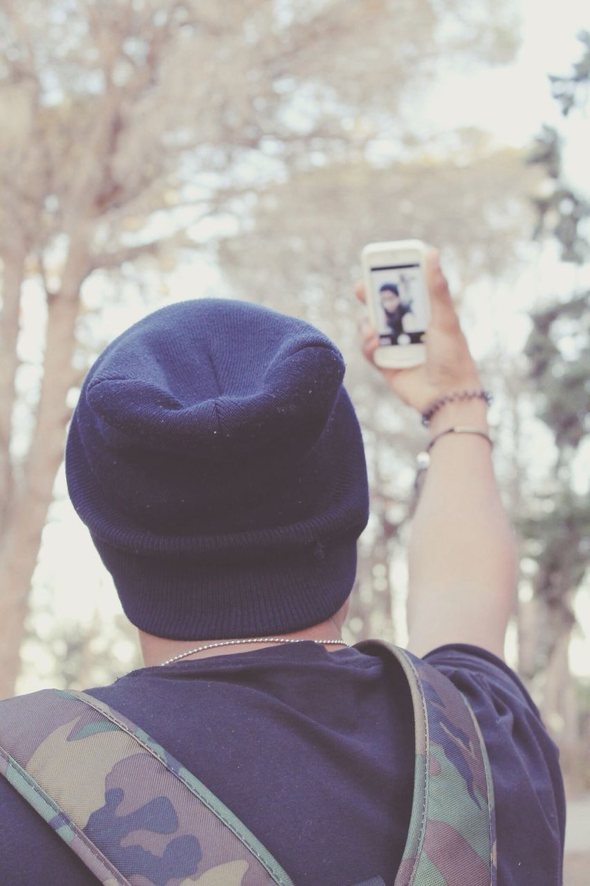 lifestyles, leisure activity, focus on foreground, close-up, holding, men, person, casual clothing, day, outdoors, headshot, part of, unrecognizable person, rear view, standing