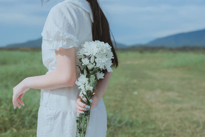 Midsection of woman standing on field