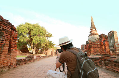 Man taking photos of the famous wat phra si sanphet temple ruins,  ayutthaya, thailand